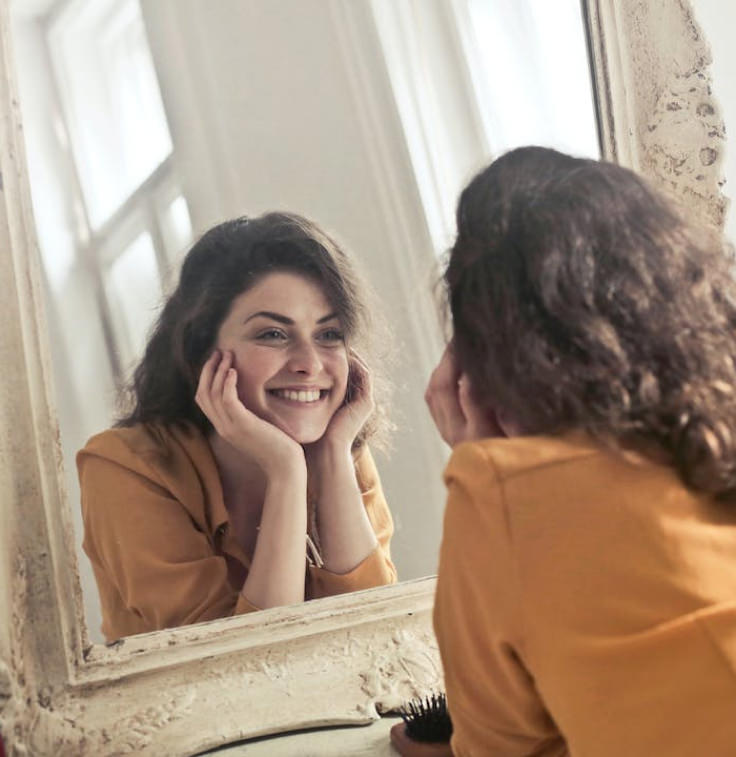 Patient smiling in a mirror during recovery